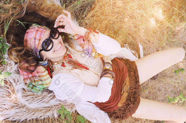 <strong>波</strong>霍风格快乐微笑的女孩肖像躺在干草和毛皮上