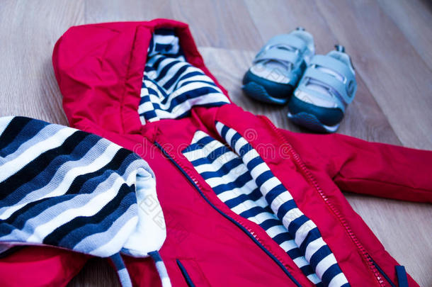 婴儿冬季服装，概念，秋季，运动鞋，帽子，玩具。 如何在冬天给婴儿穿衣服。 选择鞋子。