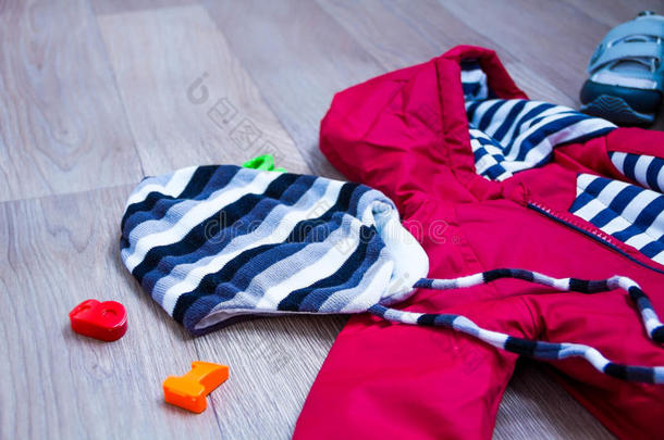 婴儿<strong>冬季服装</strong>，概念，秋季，运动鞋，帽子，玩具。 如何在冬天给婴儿穿衣服。 选择鞋子。