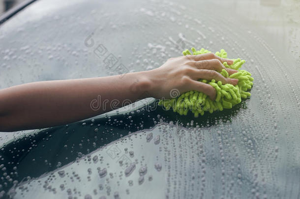 特写女人手拿刷子在汽车的挡风玻璃上洗，女人可以洗概念，女人可以做概念