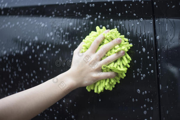 特写女人手拿刷子在黑色的汽车上洗，女人可以洗概念，女人可以做概念