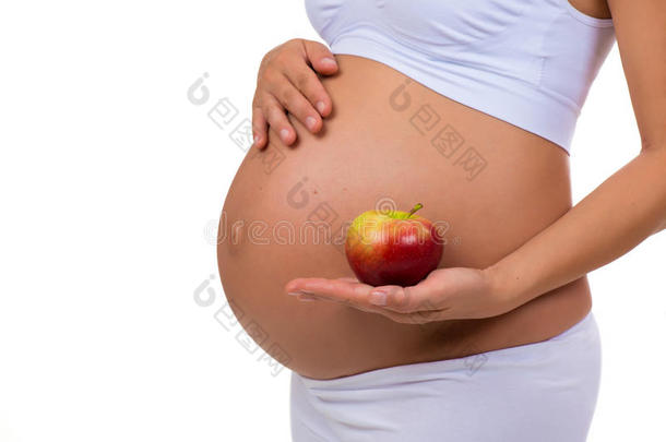 孕妇腹部和苹果的特写。 怀<strong>孕期</strong>间的维生素和健康食品