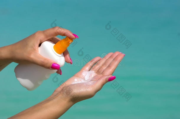 女人的手从防晒霜瓶子里放防晒霜