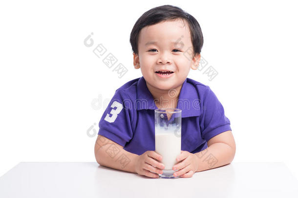 可爱的小男孩喝牛奶，留着牛奶胡子，拿着一杯牛奶