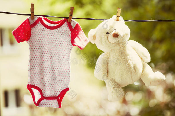婴儿衣服和泰迪熊挂在晾衣绳上