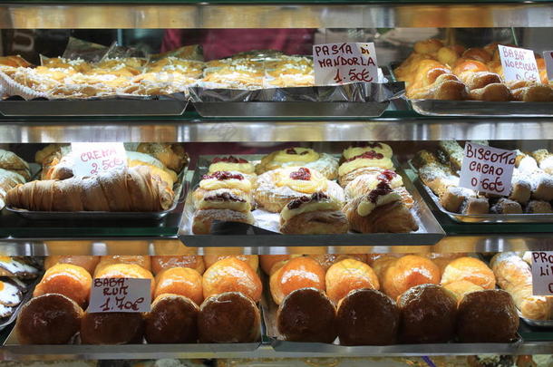 蛋糕在橱窗里。 意大利糕点店，有不同的巴巴，甜甜圈，果冻，蛋糕与水果和浆果。
