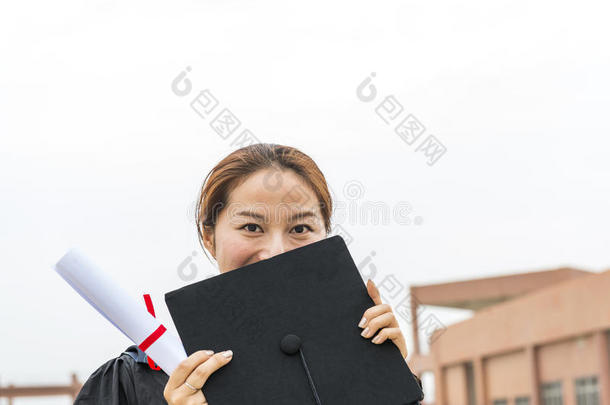 漂亮的女毕业生穿着毕业礼服在学校