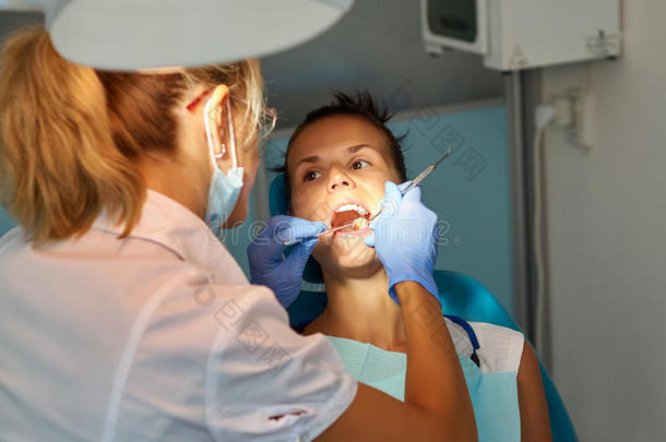 美女牙医在牙科办公室治疗病人的牙齿