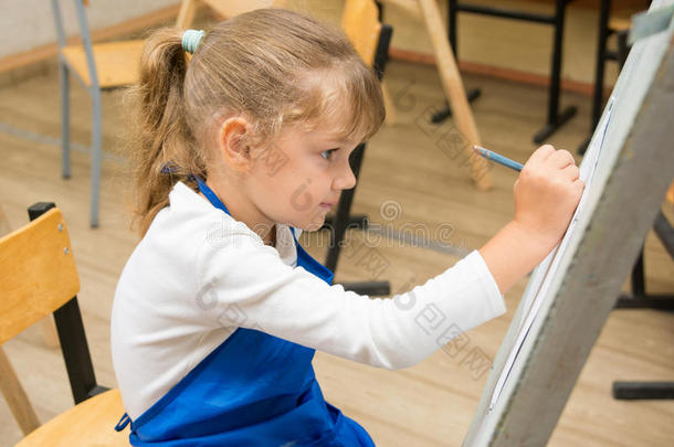 五岁的女孩在画架上画画