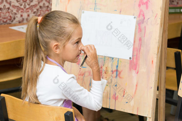 女孩在画画时仔细地听老师讲课