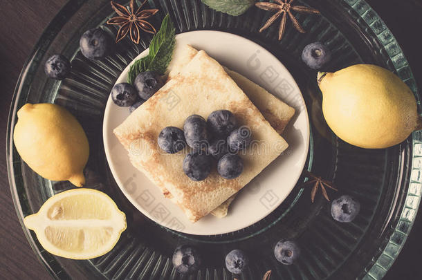 背景食品分类在一个盘子：煎饼，薄荷叶，柠檬片，八角，蓝莓