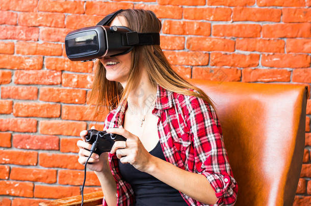 美丽的年轻女人在虚拟现实眼镜里玩游戏。