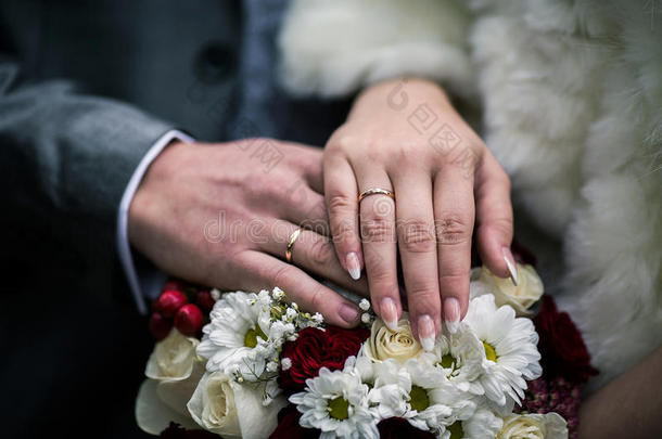 新娘和新郎旁边的结婚戒指在他们的手上，男女手与结婚戒指