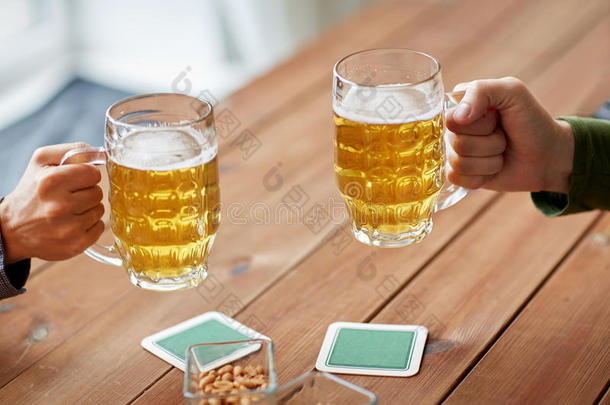 在酒吧或酒吧用啤酒杯把手闭起来