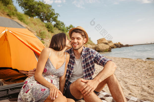 一对夫妇坐在户外露营帐篷里接吻