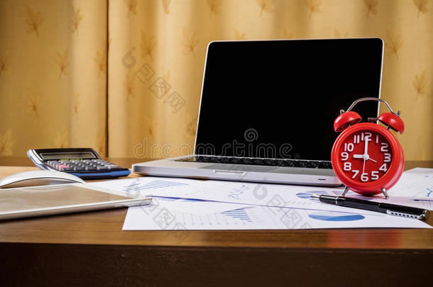 办公桌配有笔记本电脑、磁带、钢笔、分析报告、计算器