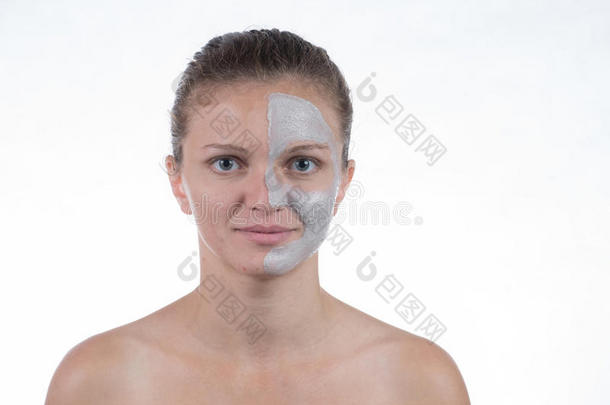 灰色粘土的化妆面具，在一个年轻女孩的脸上涂上磨砂