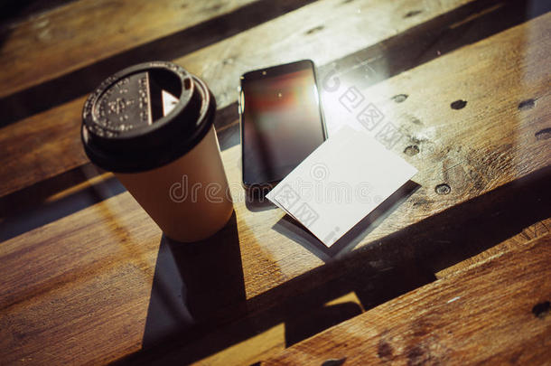 空白白色名片模拟背景。智能手机高纹理木桌带走咖啡杯咖啡。工作现代