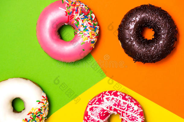 甜甜圈与糖霜的彩色块背景。 甜甜甜圈