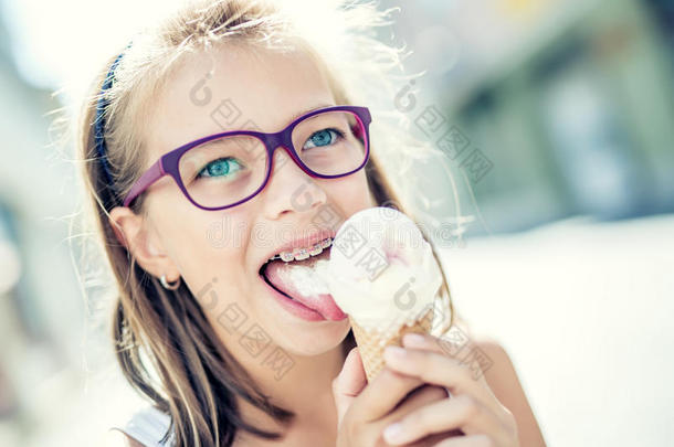 女孩。 青少年。 青春期前。 带冰淇淋的女孩。 戴眼镜的女孩。 戴牙套的女孩。 年轻可爱的白种人金发女孩穿着