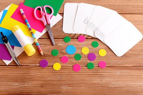 在木桌上剪卡片和圆圈，剪刀，铅笔，胶水棒，彩色纸板。 如何制作教育闪存卡