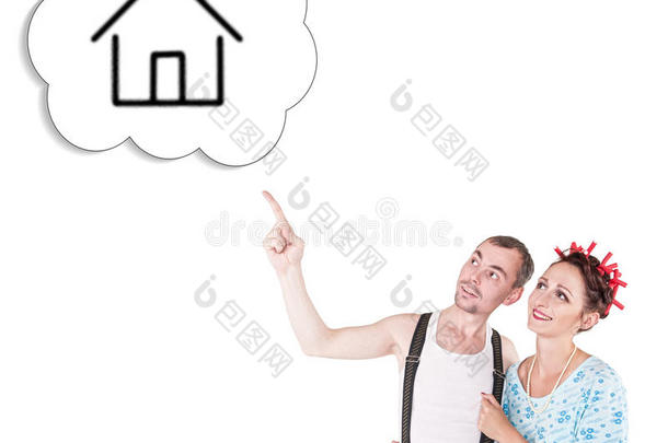 有趣的家庭夫妇拥抱和指着梦想的房子