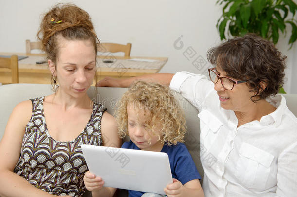 孩子和他妈妈和奶奶一起玩平板电脑