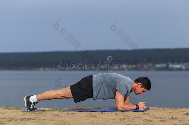 交叉健身训练健身者做木板核心运动，锻炼他的中段核心肌肉。