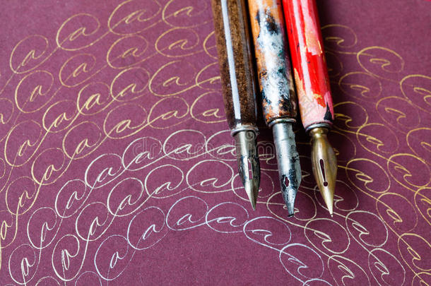 陈年钢笔，带字母a的艺术画框。字书法概念。青铜银墨水。粉红色纸背景