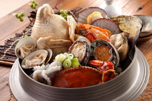 大<strong>火锅</strong>的唐皇海与新鲜章鱼，鲍鱼，螃蟹，蛤蜊，虾和<strong>鸡肉</strong>在木制韩国桌子上