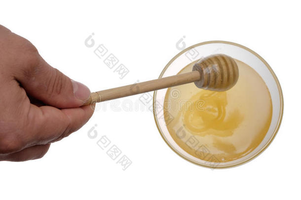 白色背景上的一碗蜂蜜和木制蜂蜜贴纸。
