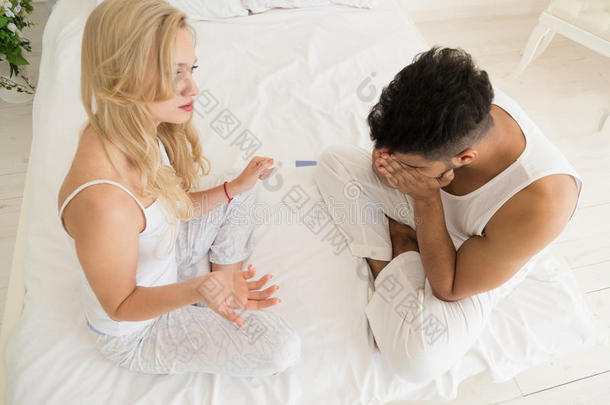 夫妻坐在床上争论，有冲突的关系问题，悲伤的负面情绪