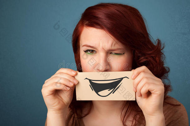 快乐可爱的女孩拿着纸和有趣的笑脸画