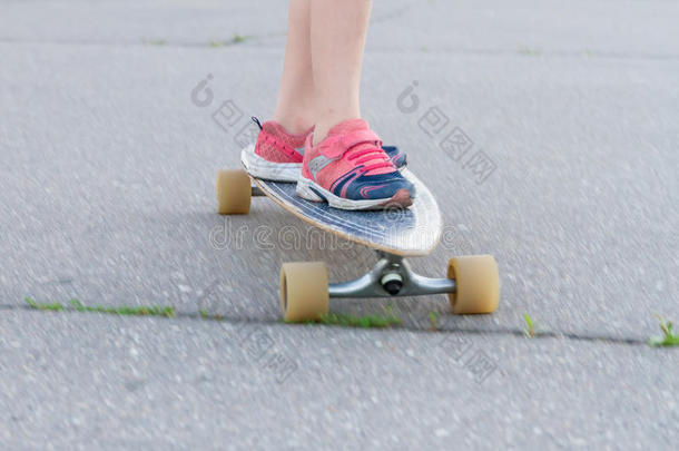 儿童滑板在城市背景，儿童`腿在长板
