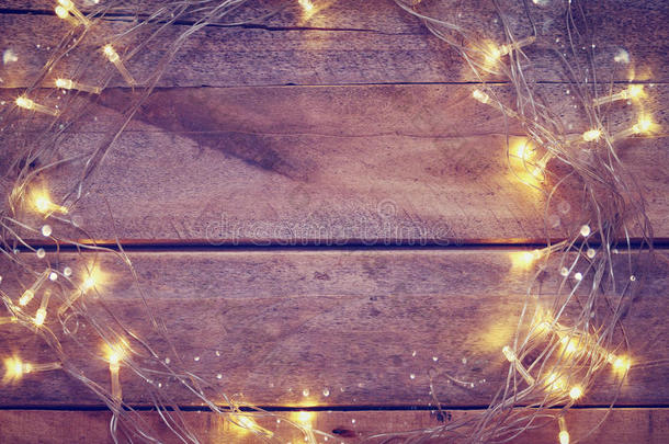 木制背景上的圣诞黄金花环灯
