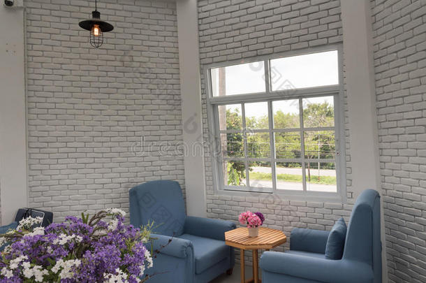 蓝色经典扶手椅在现代阁楼客厅与白色砖墙