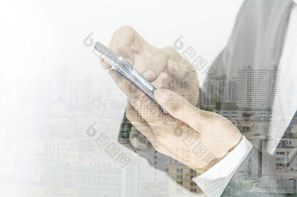 商务人士触摸智能手机和城市背景