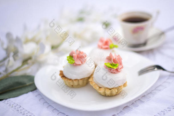 盘子上的各种高档美食纸杯蛋糕。 白色复古花边背景上装饰精美的纸杯蛋糕。