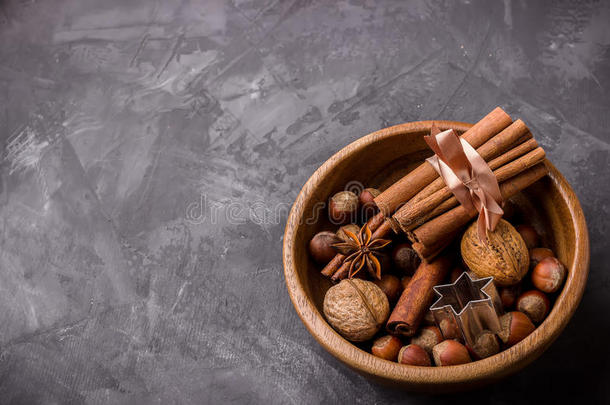 秋天收获的概念。南瓜，香料和坚果在木碗里。