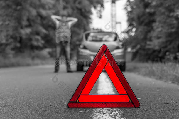 道路上的破车和红色警告三角形