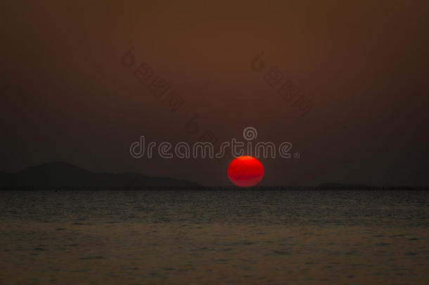 大红色日落，有海和山的背景
