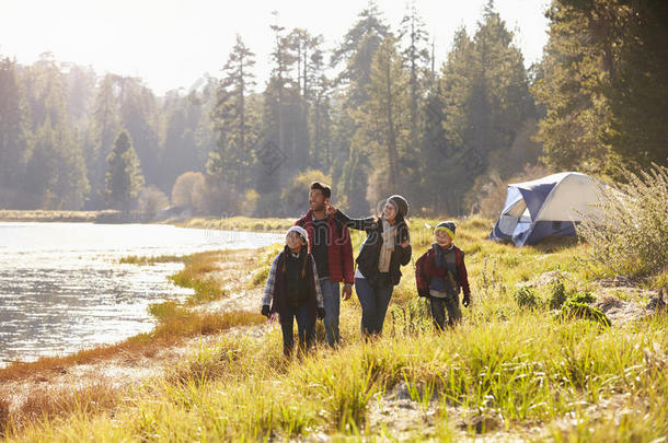 一家人在野营旅行中，走在湖边，望着远方