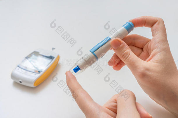 糖尿病患者使用针头和血糖仪检查血糖水平