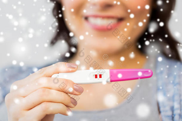 关闭快乐的女人与家庭怀孕测试