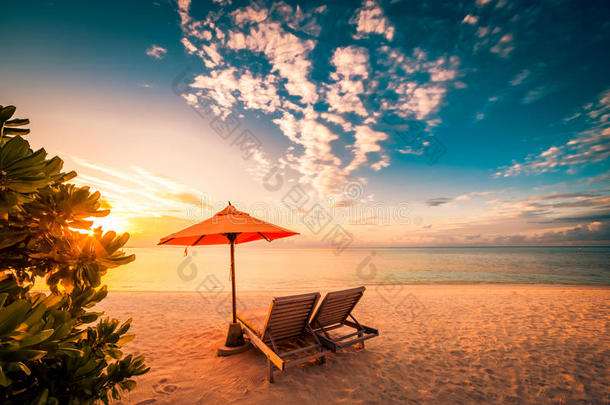 美丽的海滩日落，有太阳床和放松的心情