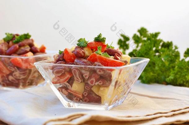 新鲜健康纯素沙拉，红豆，番茄，胡椒，红辣椒和欧芹在玻璃碗在棕色<strong>布</strong>在木制背景