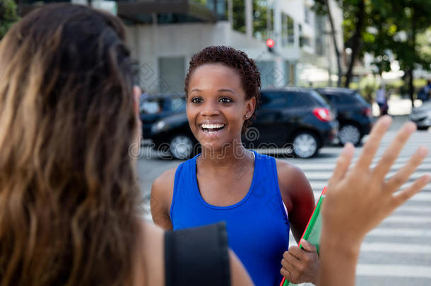 非裔美国潮人女孩在城市户外遇见一名白人女子