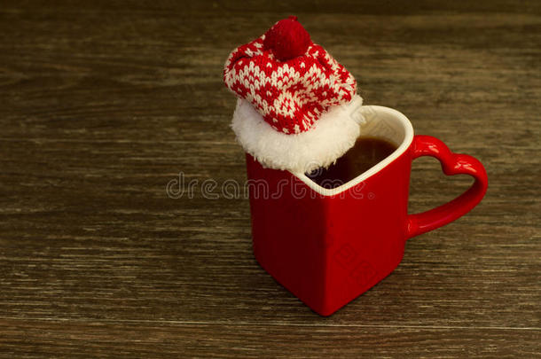 可可或热巧克力在一个红色的圆圈，红色的帽子在木制的背景上。