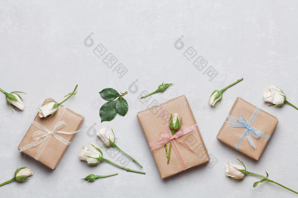 礼物或礼物盒包装在牛皮纸和玫瑰花灰色桌面视图。 平躺造型。 复制文本空间。