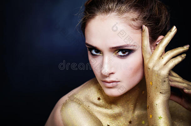 优雅的女人，金色的皮肤和迷人的派对化妆